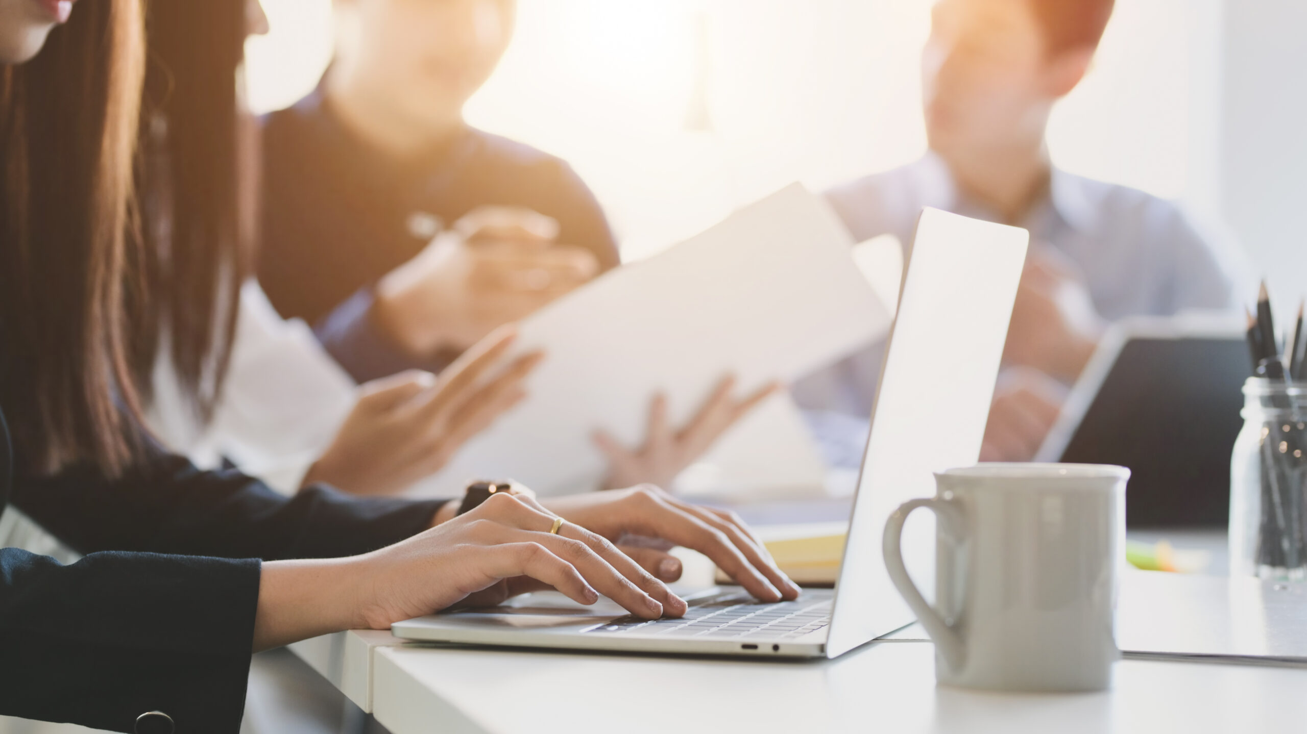 Close up view of business people typing on computer laptop while working with her team 事務所で作業している写真。SPC管理業務をイメージした写真。
